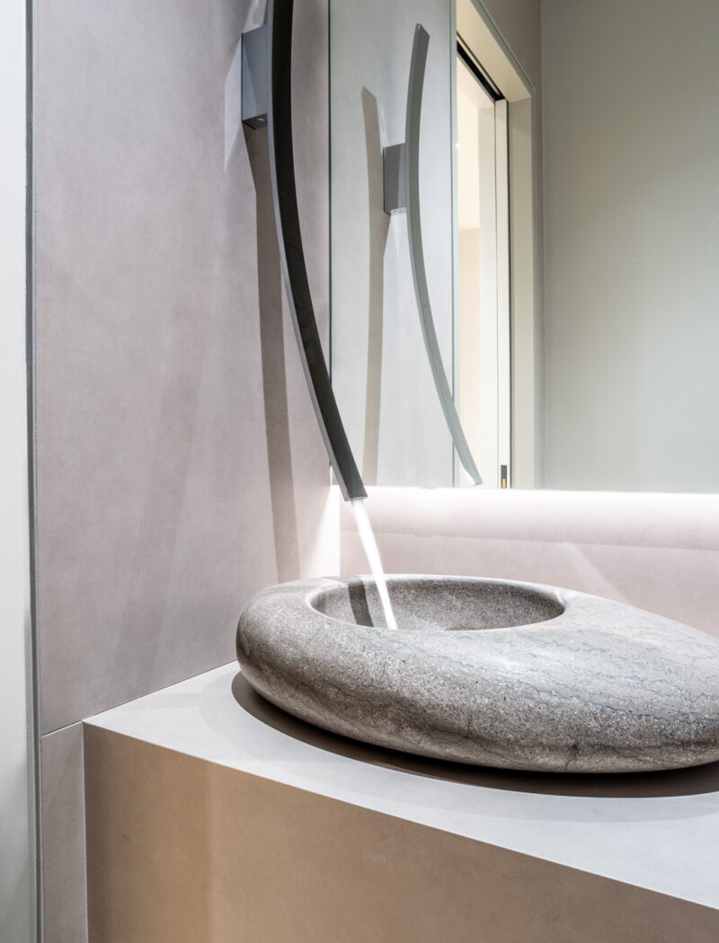 HOBI-His powder room with wall mounted ski slope faucet and stone vessel sink