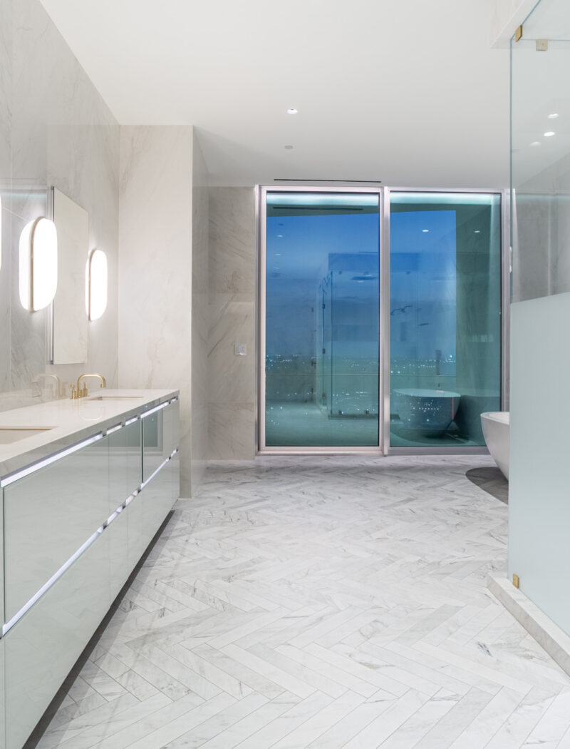 HOBI- Primary Bath clad in large format porcelain tiles with Dolomite herringbone floors